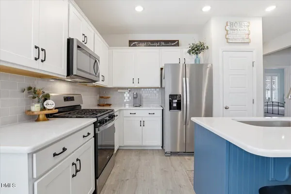 a kitchen with a table chairs and a refrigerator