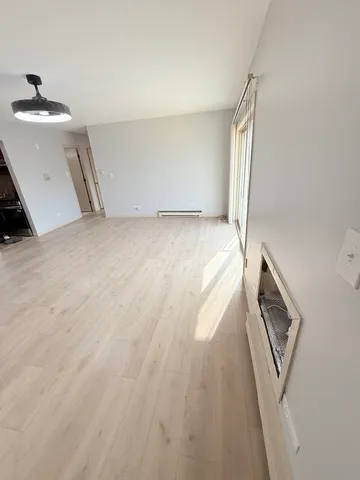 a view of a livingroom with wooden floor and staircase