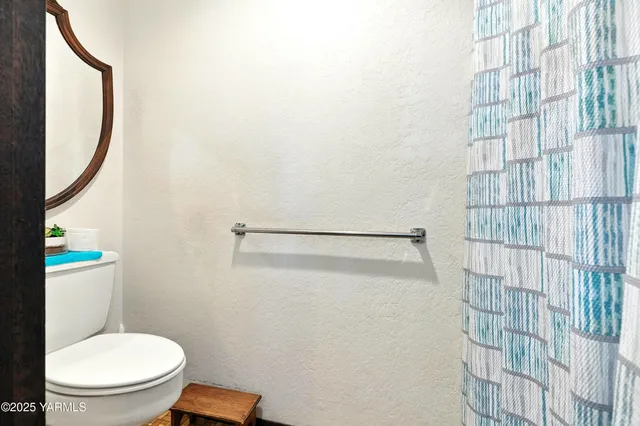 a bathroom with a toilet and a shower curtain