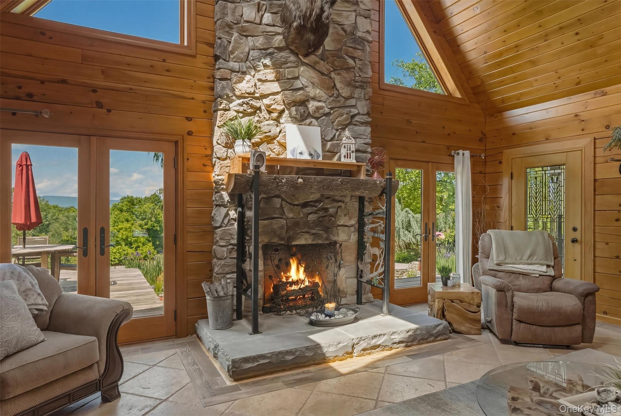 95 Judson Road Montgomery, NY 12549 - Photo 13 of 50 Handsome stone fireplace, doors out to the front patio/deck with mountain views, koi pond and grilling station (1 of 3)