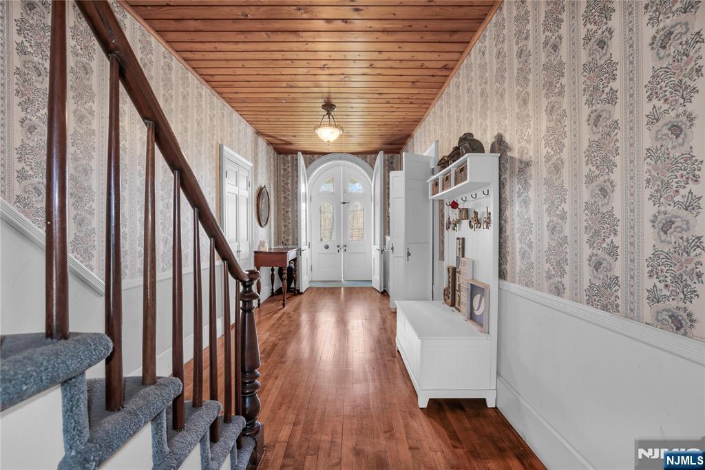 265 Little Falls Road Cedar Grove, NJ 07009 - Photo 9 of 44 a view of a hallway with wooden floor and staircase