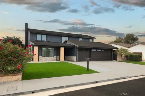 a view of a house with a yard and potted plants