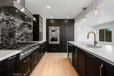 a kitchen with stainless steel appliances granite countertop a stove a sink and a refrigerator