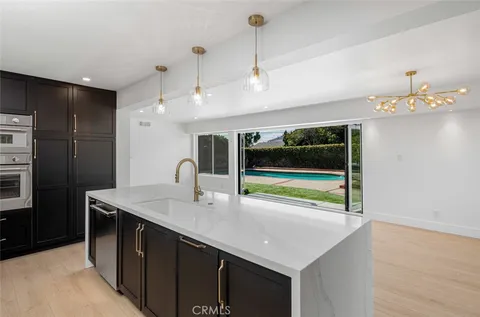 a kitchen with kitchen island a sink stainless steel appliances and a counter top space