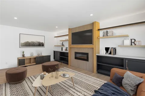 a living room with furniture a flat screen tv and a fireplace