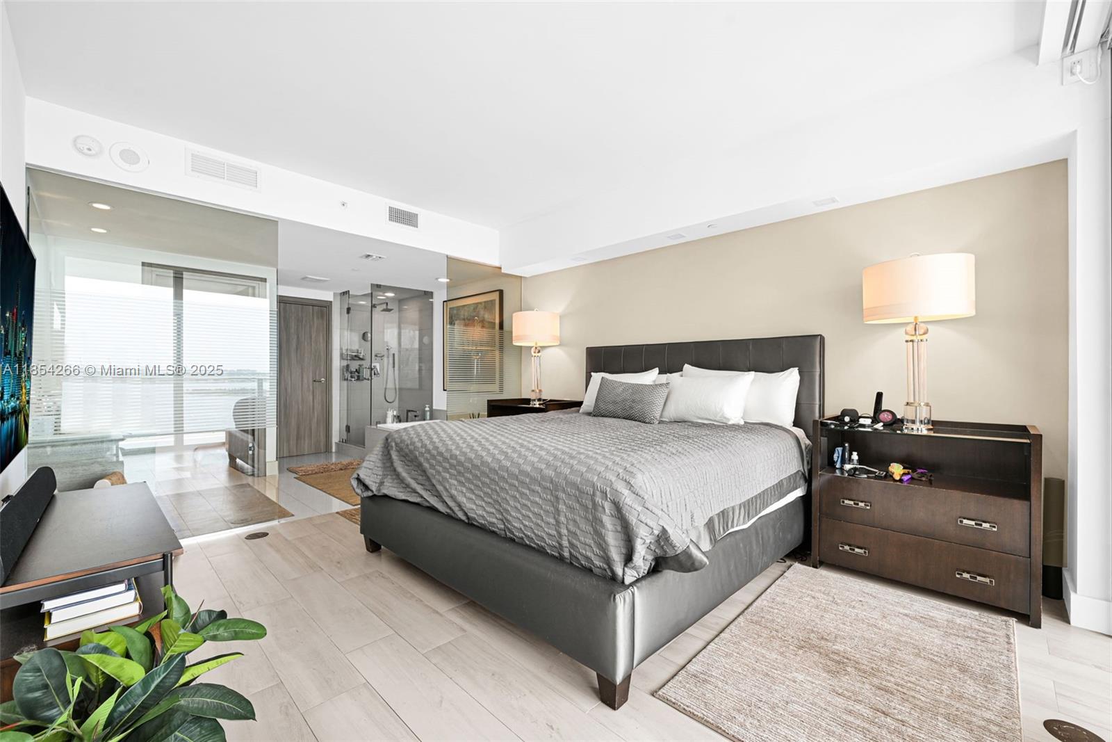 650 Northeast 32nd Street, Unit 2201 Miami, FL 33137 - Photo 13 of 35 a spacious bedroom with a bed a couch and a potted plant on the dresser