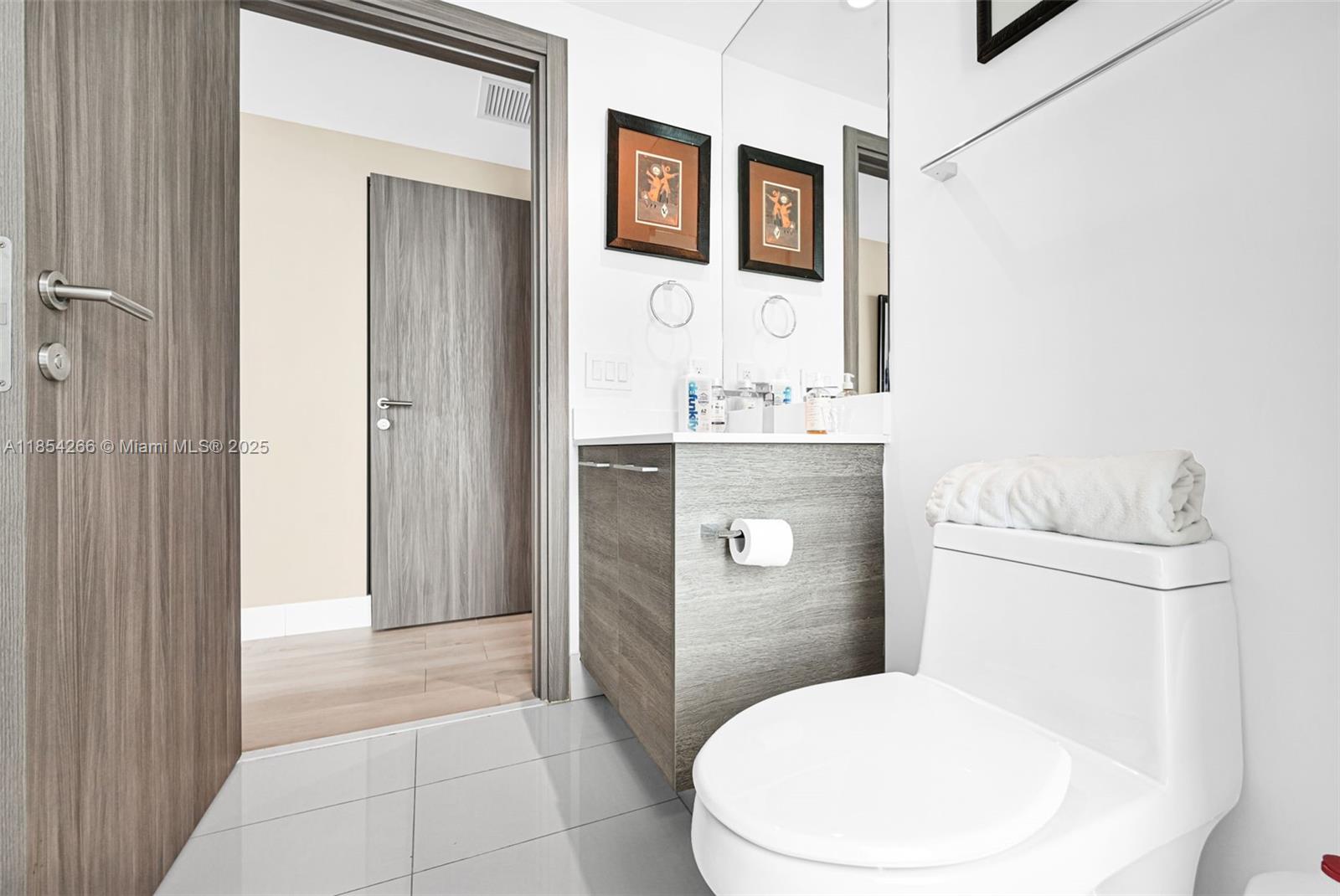 650 Northeast 32nd Street, Unit 2201 Miami, FL 33137 - Photo 27 of 35 a bathroom with a toilet a sink and mirror