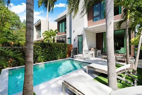 a view of a house with backyard and sitting area
