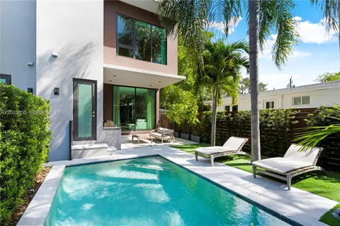 a view of a patio with table and chairs potted plants and palm tree