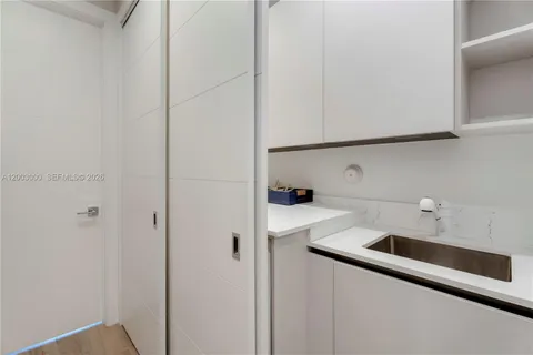a kitchen with a sink and white cabinets
