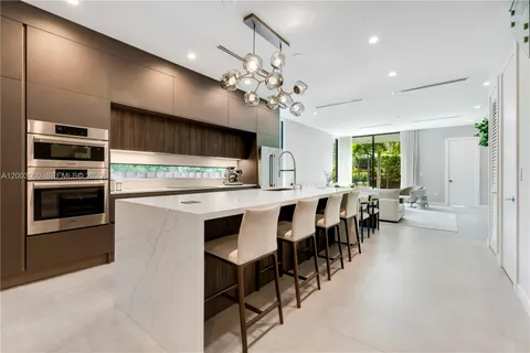 a large kitchen with lots of counter space and chandelier