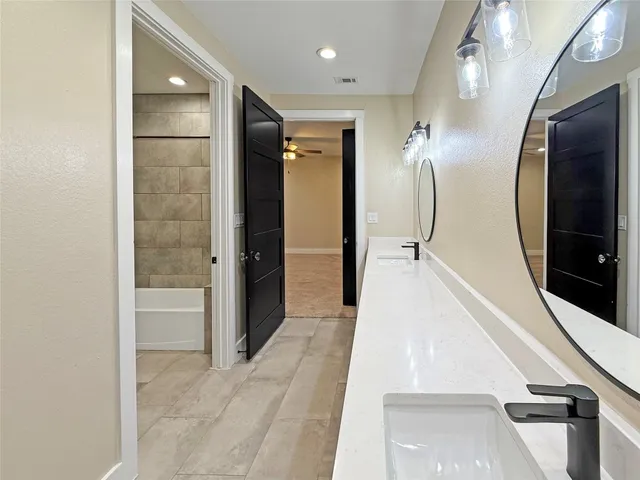 a view of an empty room and a ceiling fan and window