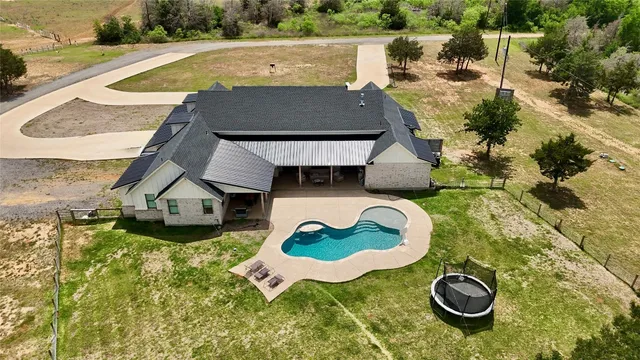 an aerial view of a house with a yard and lake view
