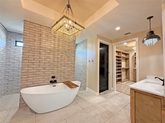 a bathroom with a tub a sink and a shower