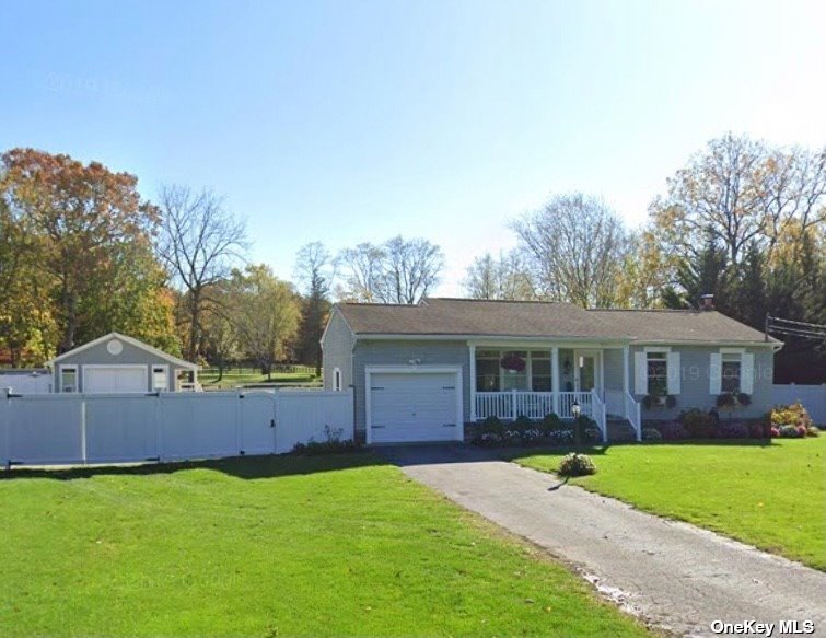 a view of house with a yard and large tree