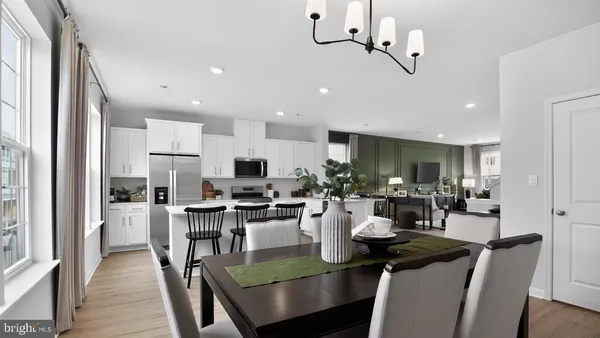 a view of a dining room with furniture a chandelier and wooden floor