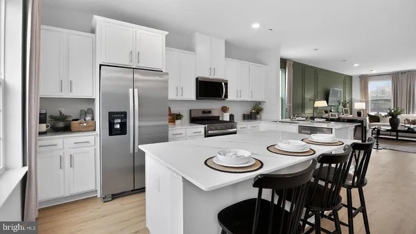 a kitchen with refrigerator and chairs