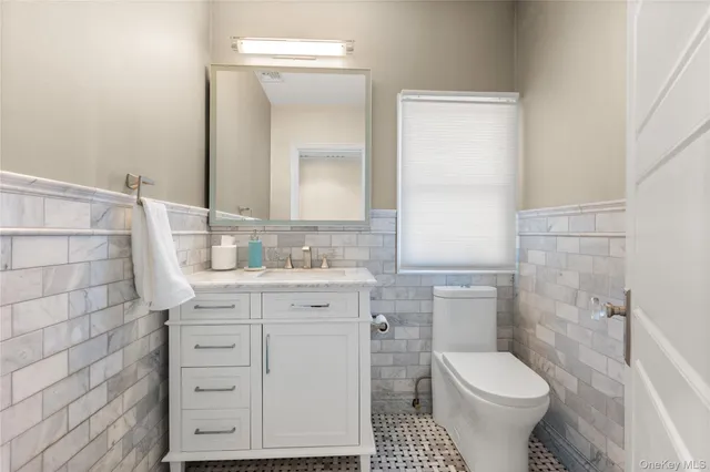 a bathroom with a granite countertop toilet sink and a mirror