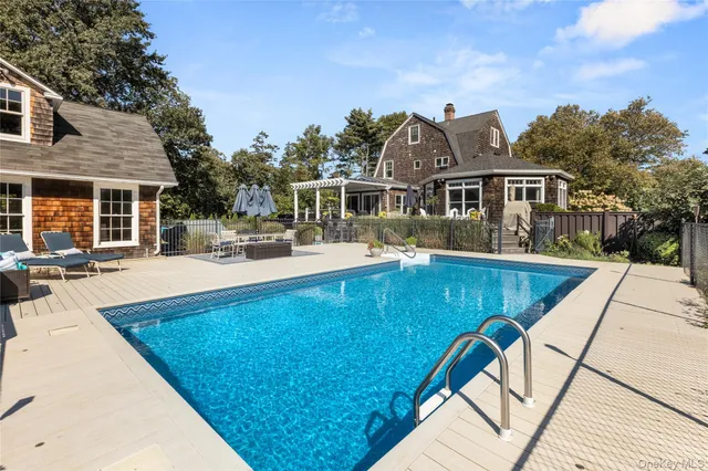 a view of a house with pool and sitting area
