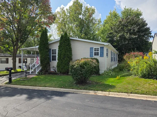 a view of a house with a yard and large trees