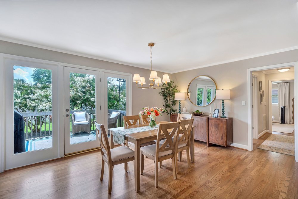 2310 Hannah Road Anderson, SC 29621 - Photo 9 of 32 Hardwood floors and a chic chandelier elevate this bright dining area, featuring glass doors that open to a serene outdoor space.
