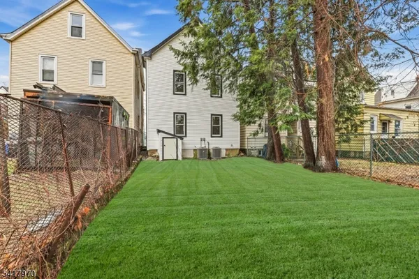 a view of a house with backyard and a tree