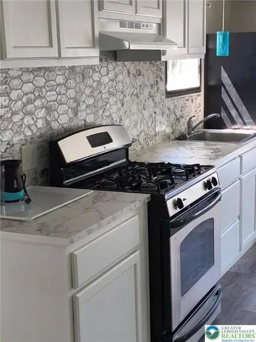 a kitchen with granite countertop a stove and a sink