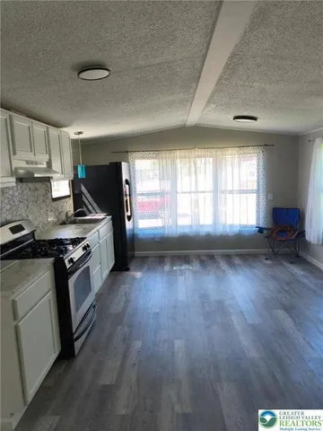 a kitchen with granite countertop wooden floors and stainless steel appliances