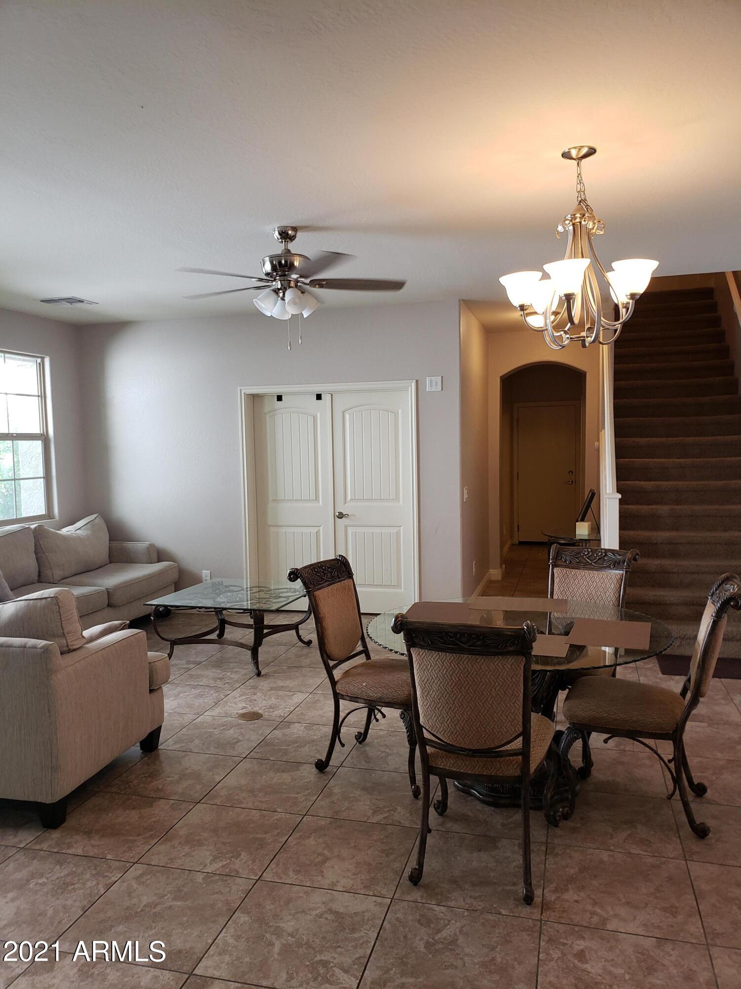 2549 North Riley Road Buckeye, AZ 85396 - Photo 6 of 46 a living room with furniture and a chandelier