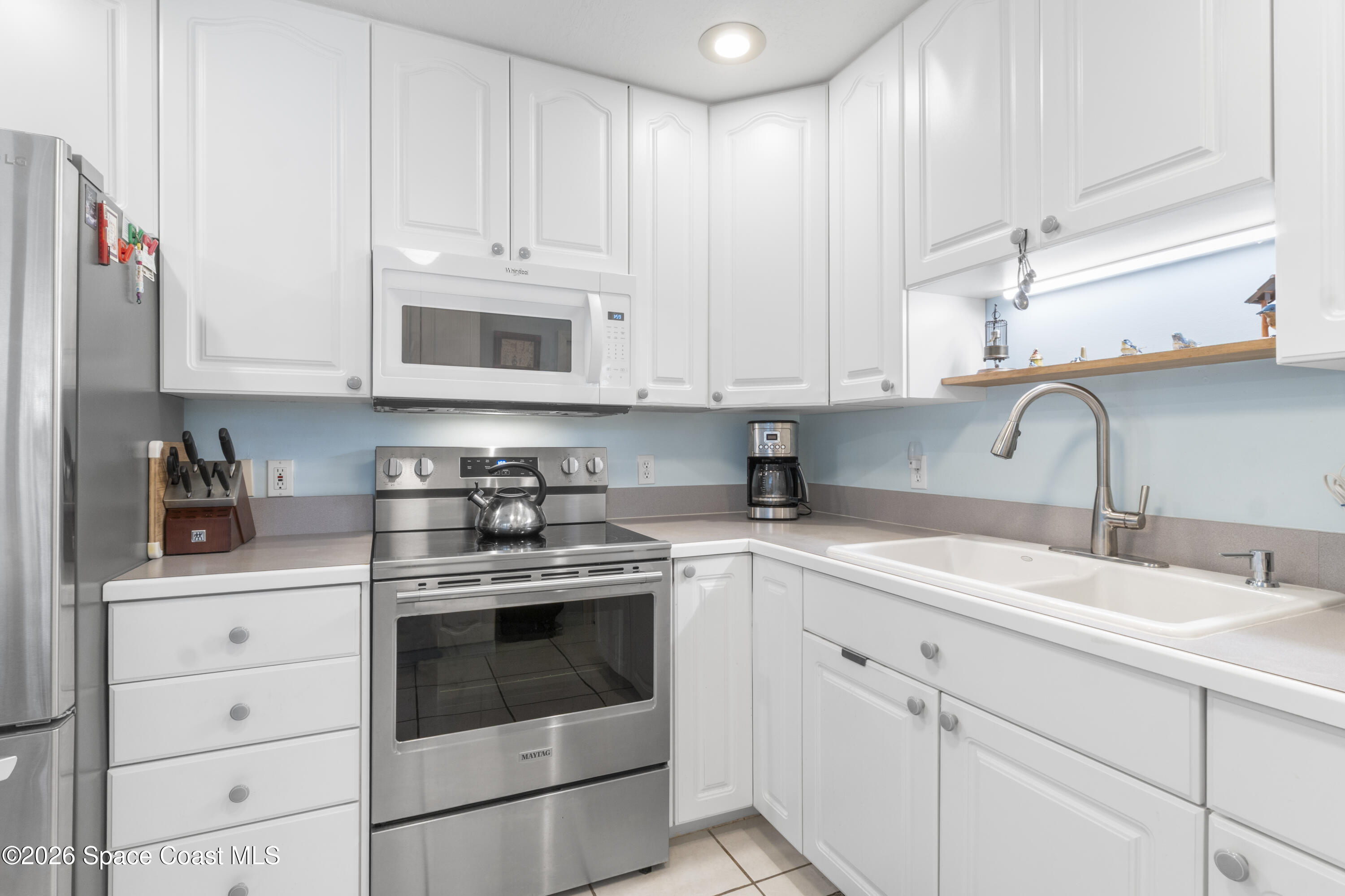 637 Roseland Road Sebastian, FL 32958 - Photo 11 of 36 a kitchen with white cabinets and white appliances