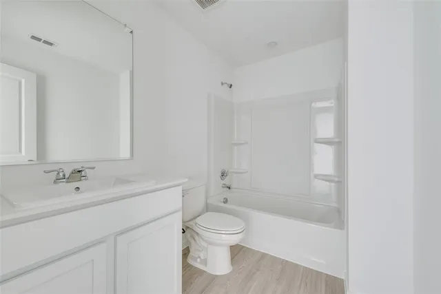a bathroom with a bathtub shower sink mirror and toilet