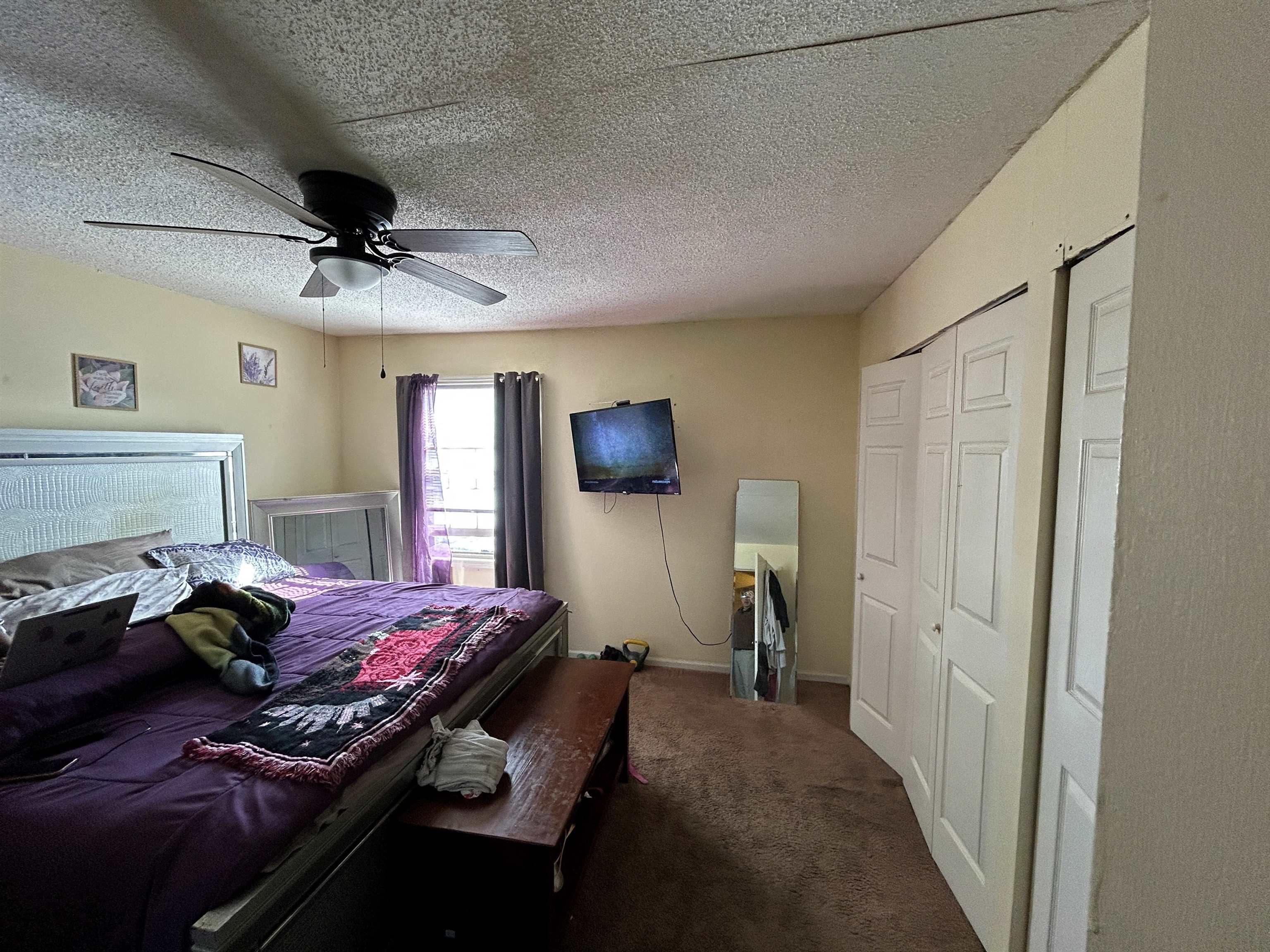 3748 Station Way Memphis, TN 38115 - Photo 9 of 11 Bedroom featuring a textured ceiling, ceiling fan, dark carpet, and a closet