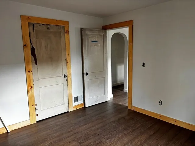 an empty room with wooden floor and closet
