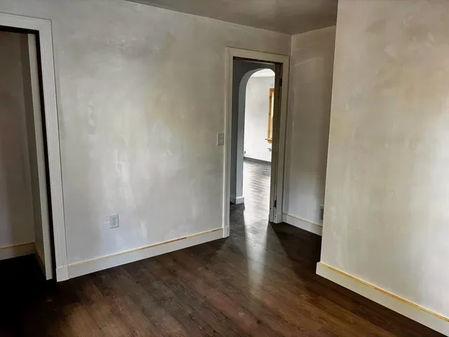 an empty room with wooden floor and closet