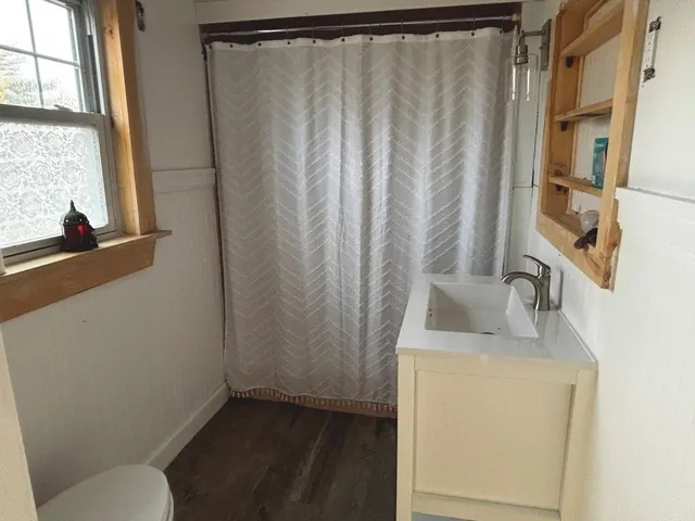 a bathroom with a sink a toilet and a window