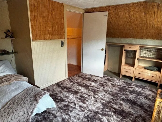 a bedroom with a bed and a refrigerator
