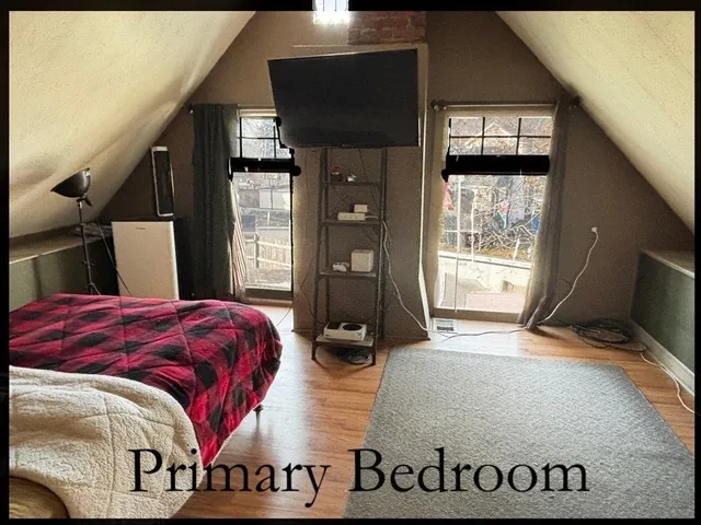 a bedroom with a bed and a flat tv screen on the dresser