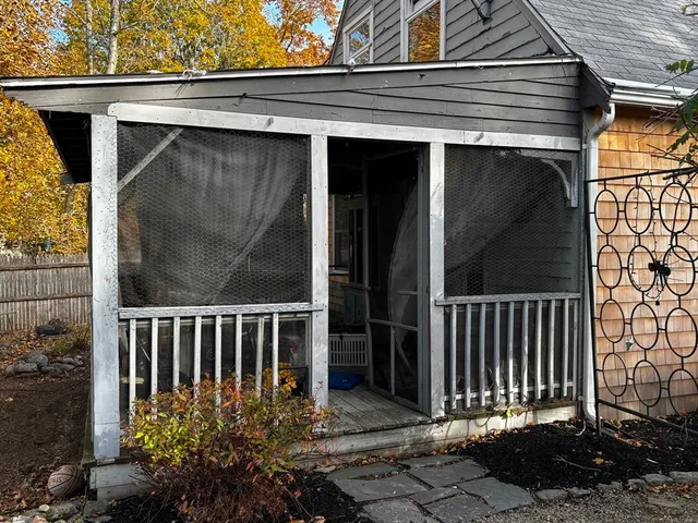 a view of a house with a small yard and wooden floor and fence