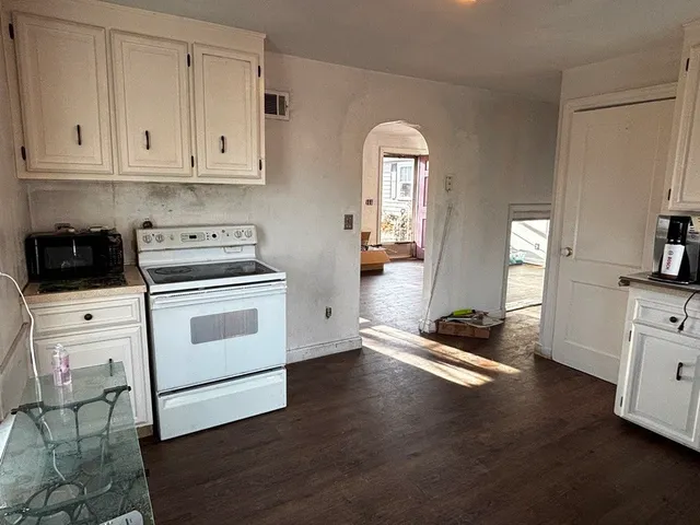 a kitchen with granite countertop white cabinets and white appliances