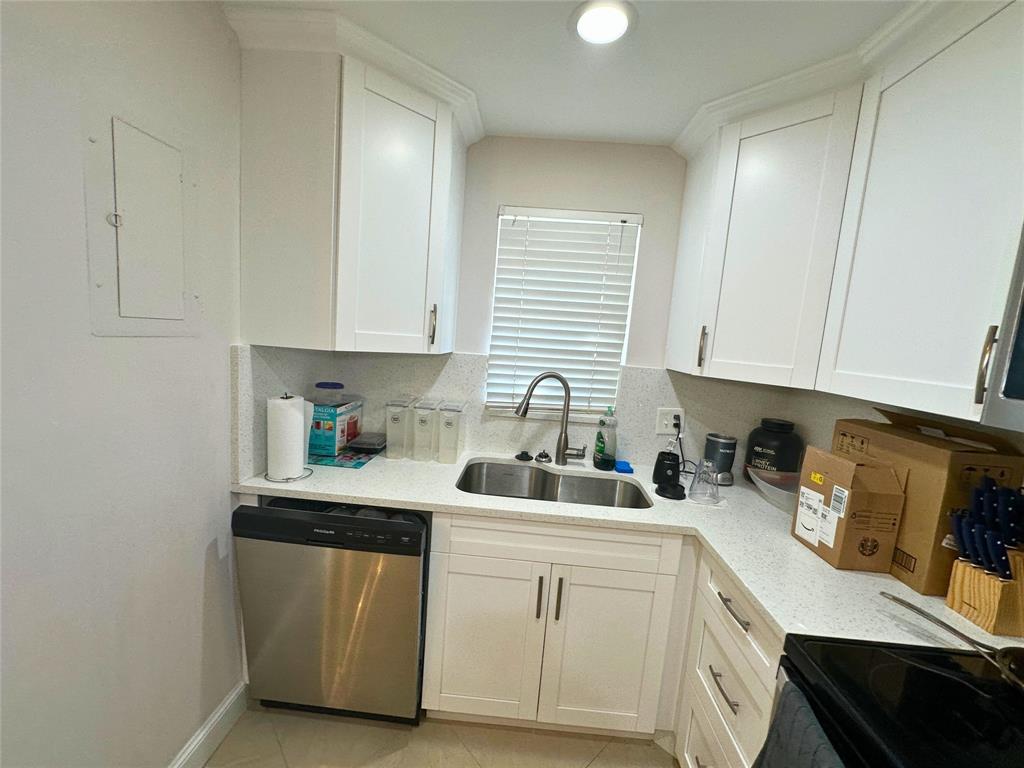2420 DC Country Club Boulevard, Unit 306 Deerfield Beach, FL 33442 - Photo 11 of 23 a kitchen with stainless steel appliances granite countertop a sink dishwasher a stove and white cabinets with wooden floor