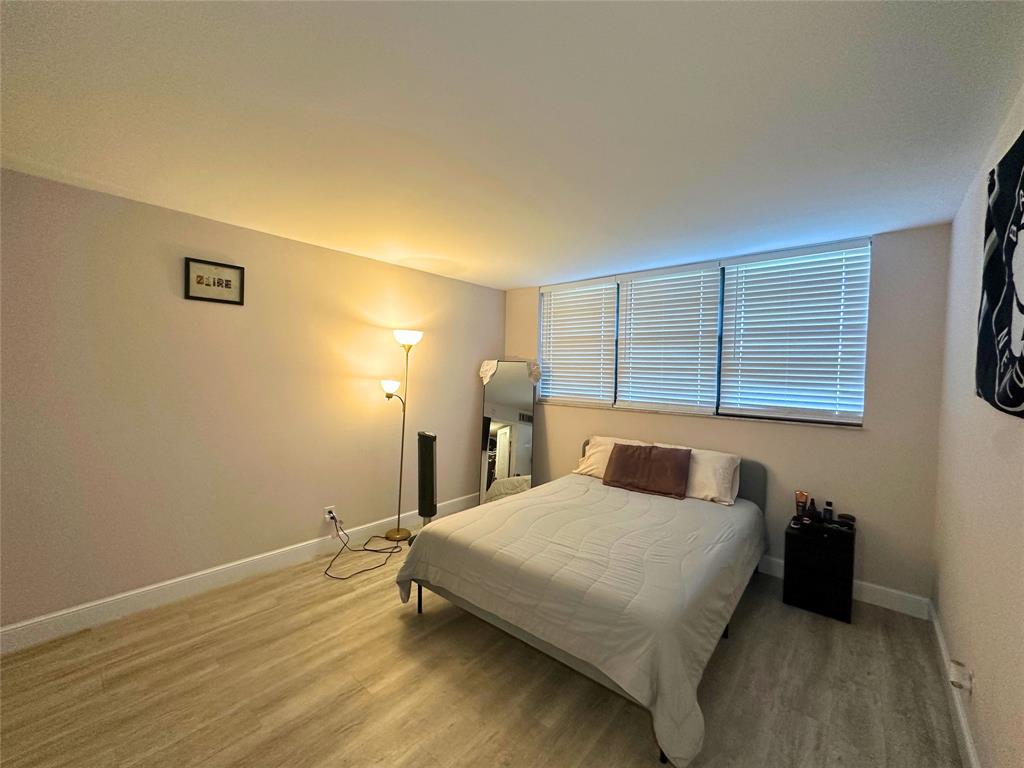 2420 DC Country Club Boulevard, Unit 306 Deerfield Beach, FL 33442 - Photo 13 of 23 a bedroom with a bed and a night stand