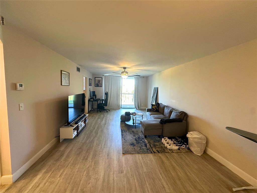2420 DC Country Club Boulevard, Unit 306 Deerfield Beach, FL 33442 - Photo 4 of 23 a living room with furniture and a wooden floor