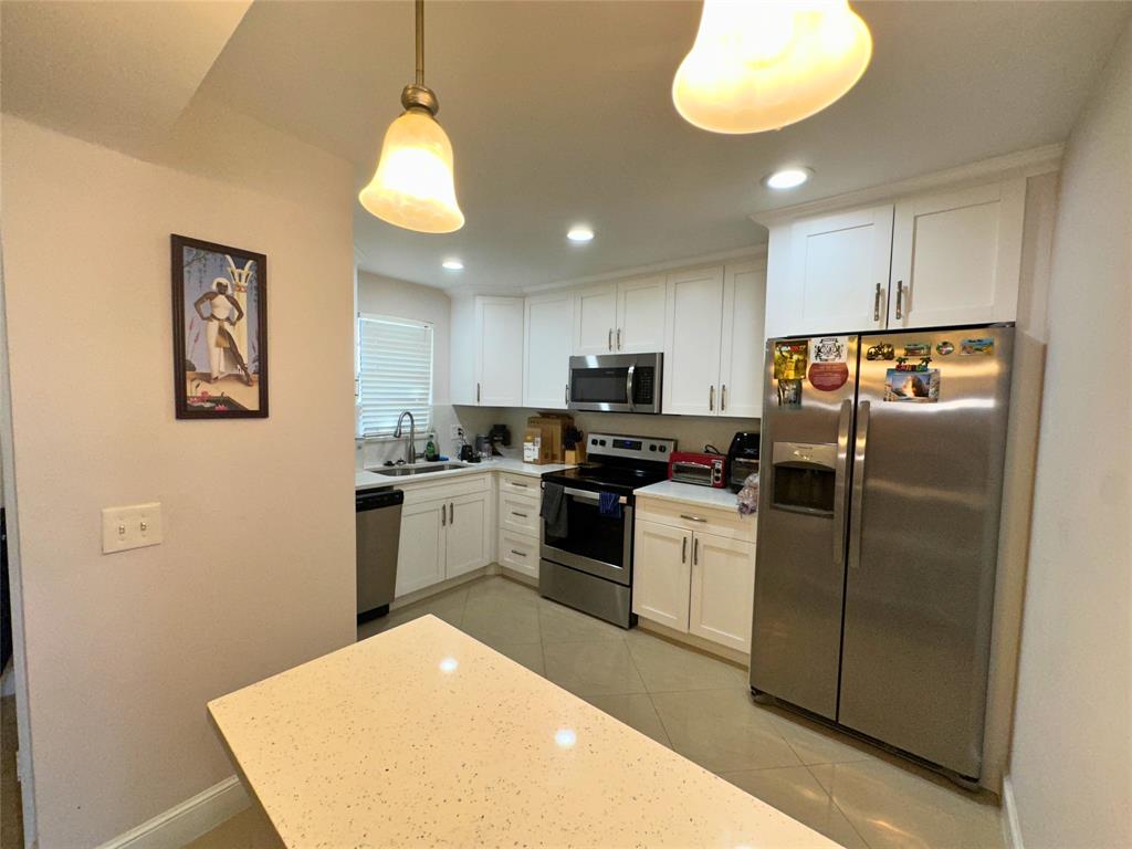 2420 DC Country Club Boulevard, Unit 306 Deerfield Beach, FL 33442 - Photo 7 of 23 a kitchen with a refrigerator and a sink