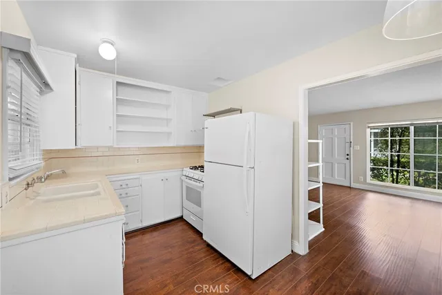 a view of a kitchen with wooden floor and electronic appliances