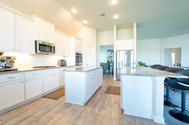 a kitchen with kitchen island granite countertop a sink counter top space and cabinets