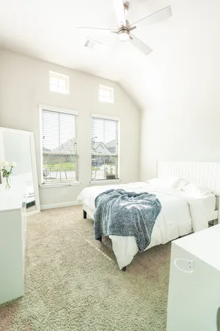 a spacious bedroom with a bed and a large window