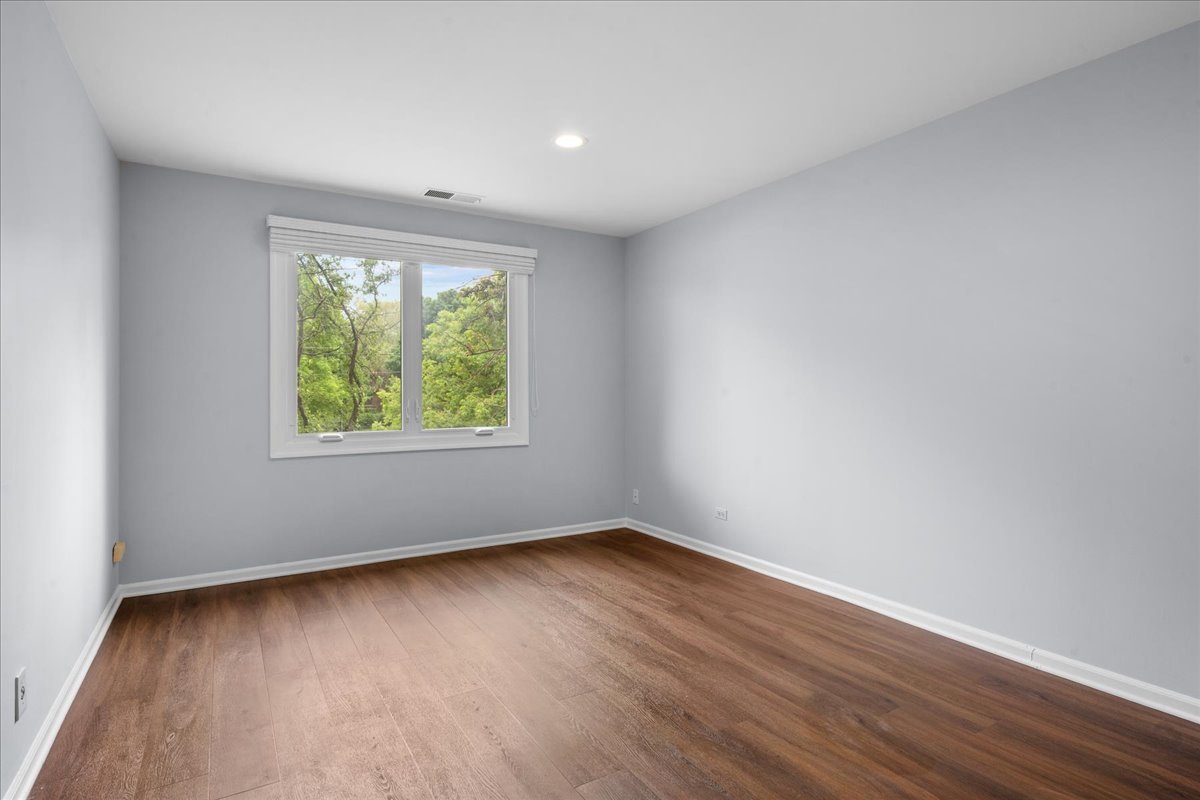 1795 Lake Cook Road, Unit 107 Highland Park, IL 60035 - Photo 17 of 26 an empty room with wooden floor and windows
