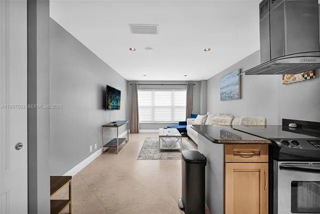 a view of a kitchen with a sink wooden cabinets and stainless steel appliances