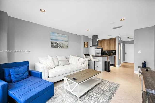 a living room with furniture and kitchen view