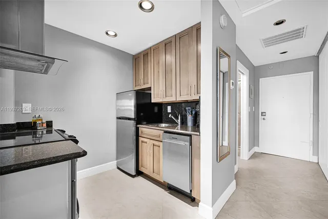 a kitchen with cabinets and a refrigerator